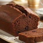 Freshly baked Chocolate Cream Cheese Pound Cake on a fine porcelain plate, with a slice showing its creamy, chocolatey interior and pockets of chocolate chips